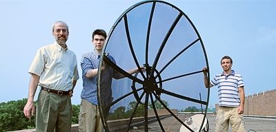 Princeton faculty and students have collaborated to develop an innovative satellite system, called Hermes, to track the migratory patterns of small birds. Professors Jeremy Kasdin of mechanical and aerospace engineering and Martin Wikelski of ecology and evolutionary biology, who first proposed the idea, are now seeking support to launch the project. From left, Kasdin and class of 2007 members Frank Mycroft and Stephen Savin hope to use the radio dish antenna located on the roof of Jadwin Hall in future simulations of the Hermes system. (Photo byDenise Applewhite) Students with satellite dish